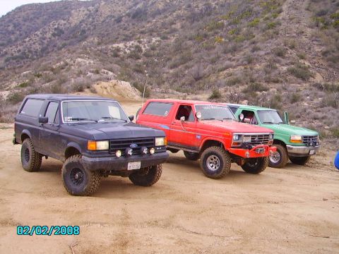 1990 Ford Bronco - Three Ford Bronco SUVs are parked on a dirt road with hills in the background. The date 02/02/2008 is visible.