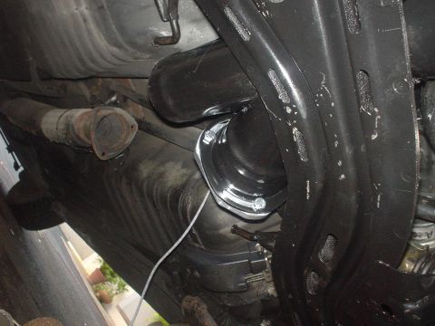 1993 Mazda MX-6 - Close-up of exhaust pipe and suspension components from underneath a vehicle.