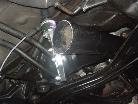 1993 Mazda MX-6 - Undercarriage view of exhaust system components, including a black pipe and a canister with visible text.