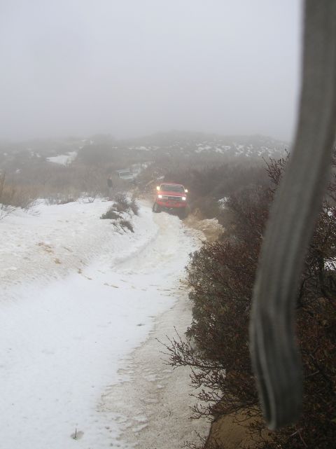 1985 Ford Bronco - Two SUVs navigate a challenging snowy and foggy trail.