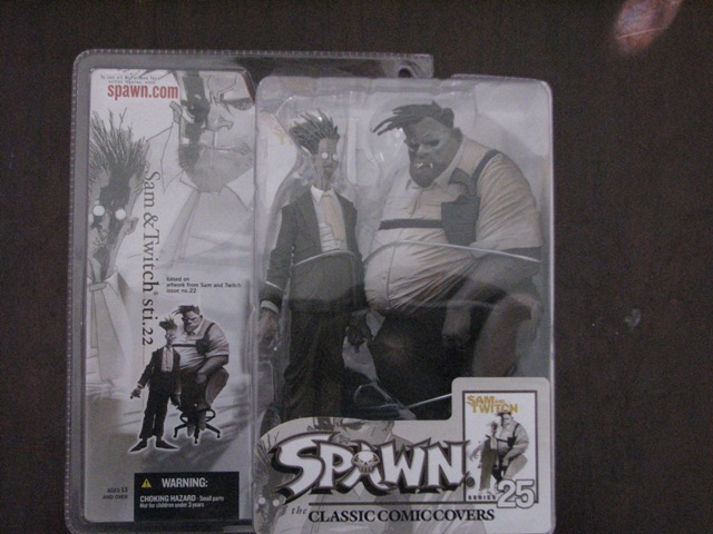 Spawn toy figures in packaging, one with a large man sitting