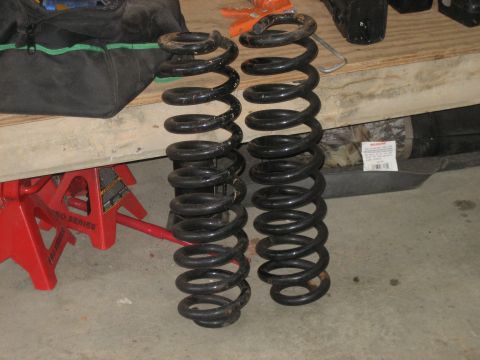 1996 Ford Bronco - Two black coil springs are shown, one slightly taller than the other, on a jack stand.