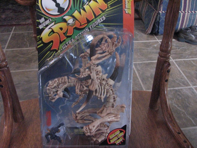 Spawn action figure in plastic packaging, showing a skeletal creature and a small figure