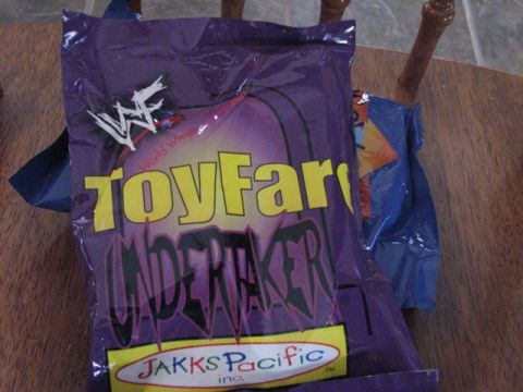 1991 Ford Bronco - A WWF Undertaker bag is shown on a wooden table, with another blue bag behind it.