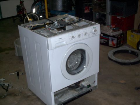 2005 Ford Mustang - A washing machine is shown with its top cover removed, exposing its internal wiring and parts.