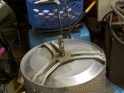 2005 Ford Mustang - A close-up view of a washing machine drum, showing its internal components and a blue laundry basket.