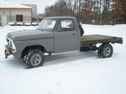 1979 Ford F-150 - This 1979 Ford F-150 flatbed truck is parked in a snowy outdoor setting.