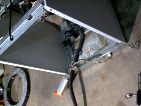 2005 Ford Mustang - The interior of a washing machine is shown with its internal components and wiring exposed.
