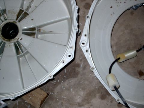 2005 Ford Mustang - Two halves of a washing machine drum are shown, revealing internal fins and a cable with foam insulation.