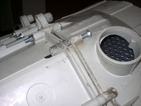 2005 Ford Mustang - This image shows a close-up of a plastic part with various metal fasteners and a grate.
