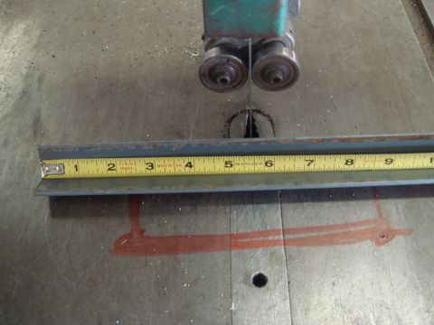 1996 Ford Bronco - L-bracket being measured on a band saw table with a tape measure.