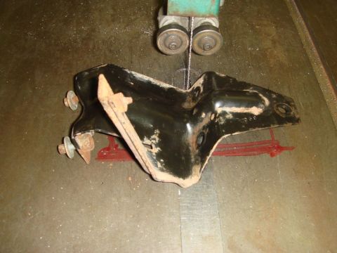 1996 Ford Bronco - A metal bracket is positioned on a workbench, ready for cutting by a band saw.