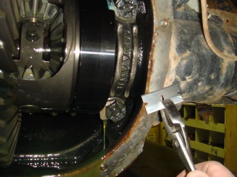 1996 Ford Bronco - A razor blade is used to scrape gasket material from a vehicle's differential housing.