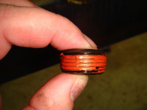 1996 Ford Bronco - A close-up view shows a small, orange-banded part being held between two fingers.