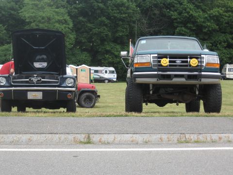 1996 Ford Bronco - A lifted green Ford F-Series truck is parked on grass with its front end facing the camera.