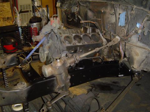 1979 Ford Bronco - Vehicle chassis and engine components are visible during a restoration project in a garage setting.