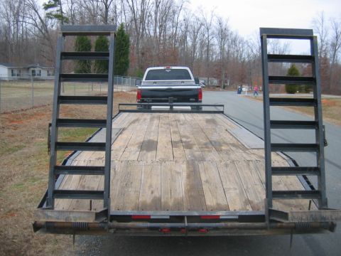1992 Ford Mustang - A trailer carries a pickup truck on a residential street.