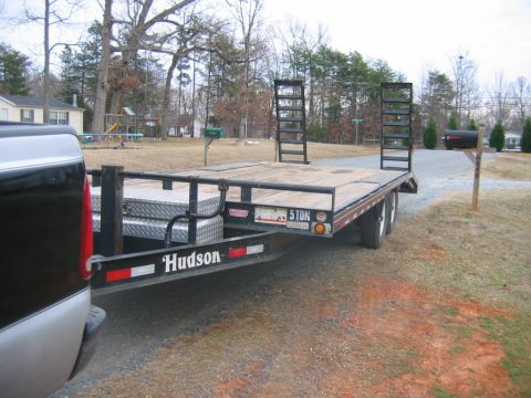 1992 Ford Mustang - A flatbed trailer, branded 'Hudson' and marked '5 TON', is parked in a residential driveway.