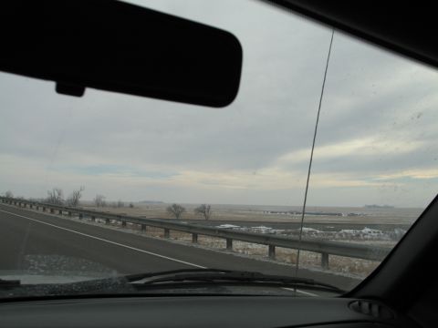 1995 Ford Bronco - View from inside a vehicle on a highway, with guardrails and fields visible under an overcast sky.