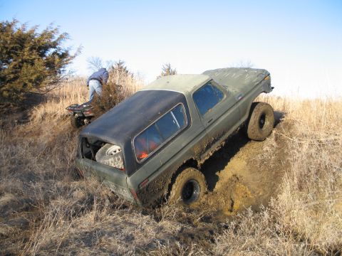 1995 Ford Bronco - A person on an ATV watches as a Ford Bronco gets stuck in a muddy ditch.