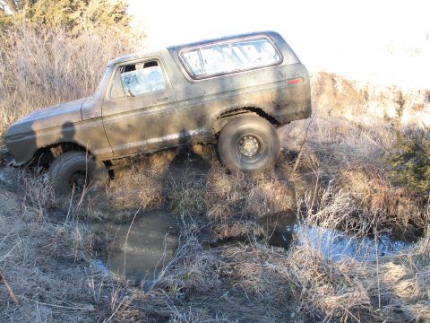 1995 Ford Bronco - Ford Bronco stuck in a muddy ditch off-road.