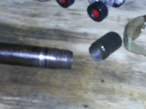 1978 Ford Bronco - Close-up of a metal shaft and a cylindrical component, possibly automotive parts.