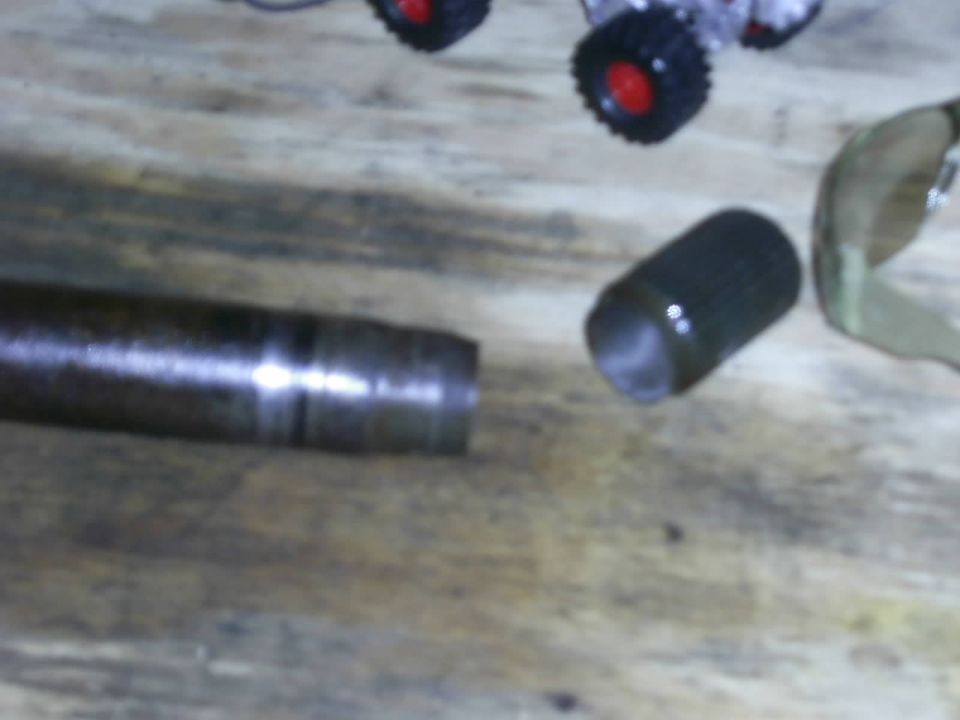 Metal shaft with a collar and a separate cylindrical part on a wooden surface