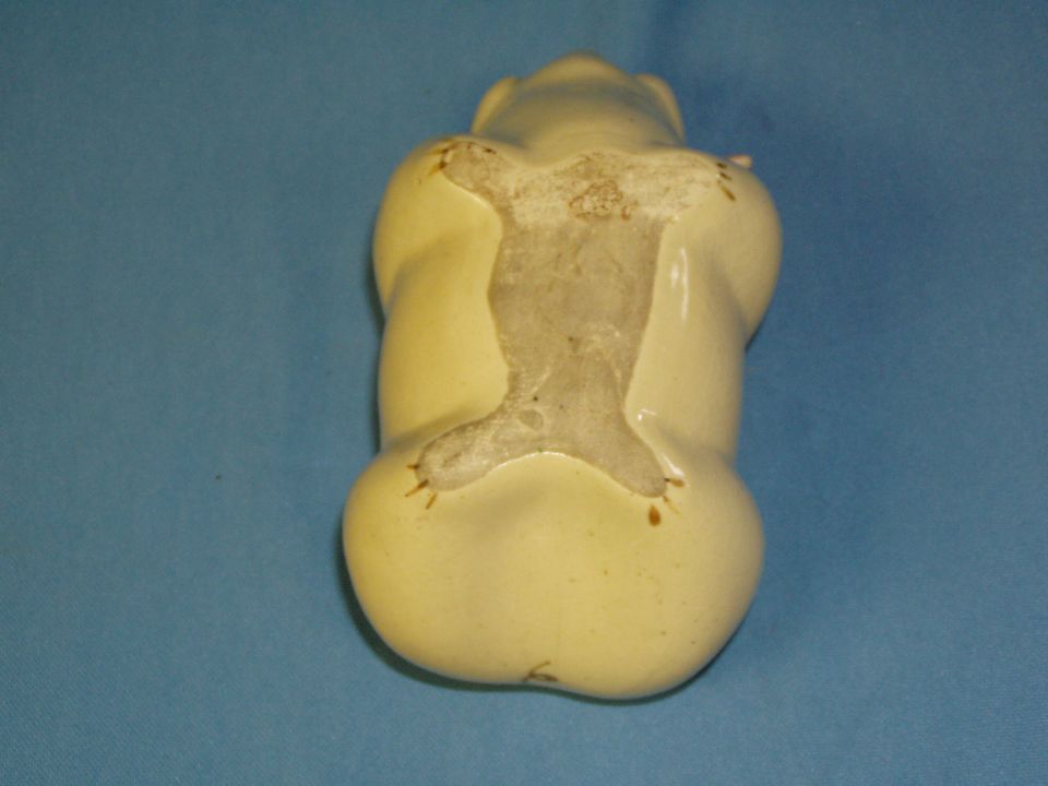 Underside of a ceramic pig piggy bank showing unglazed base