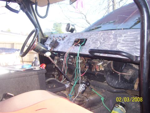 1978 Ford Bronco - Interior view of a vehicle with exposed wiring and a roll cage, likely undergoing modifications.