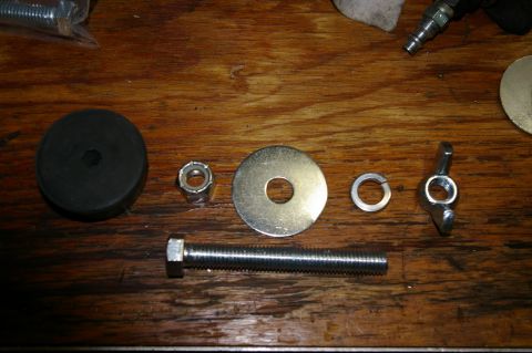 1986 Ford Bronco - Hardware components for mounting a Hi-Lift jack are laid out on a wooden surface.