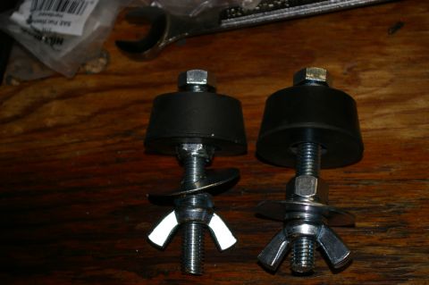 1986 Ford Bronco - Two pieces of Hi-Lift jack mounting hardware are shown, each a rubber bumper, threaded bolt, and wing nut for attachment.
