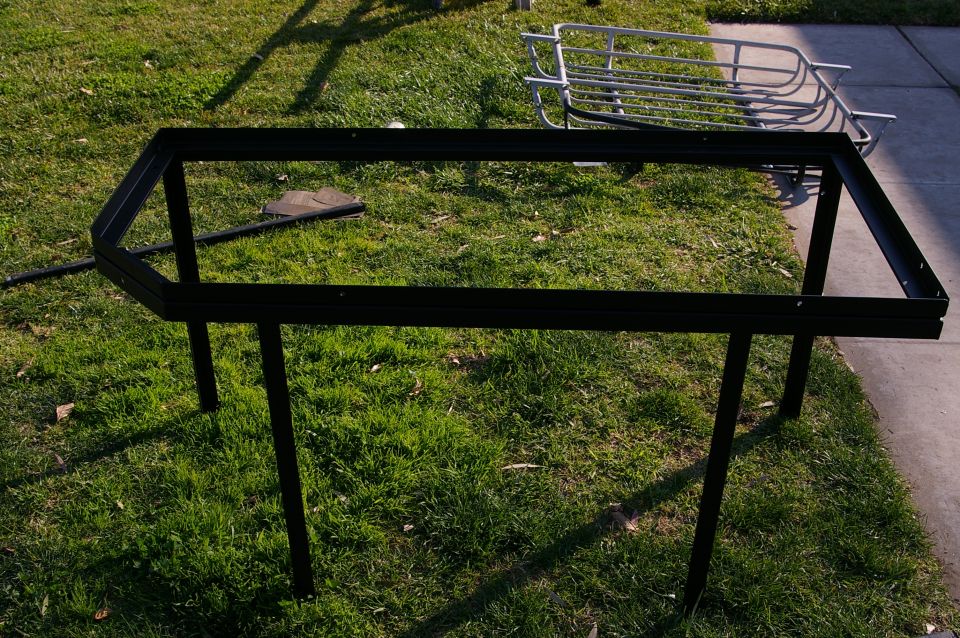 Black metal rack frame with four legs on grass