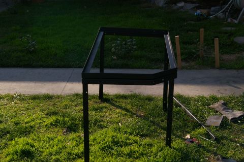 1986 Ford Bronco - A metal rack frame is assembled outdoors on a grassy lawn.