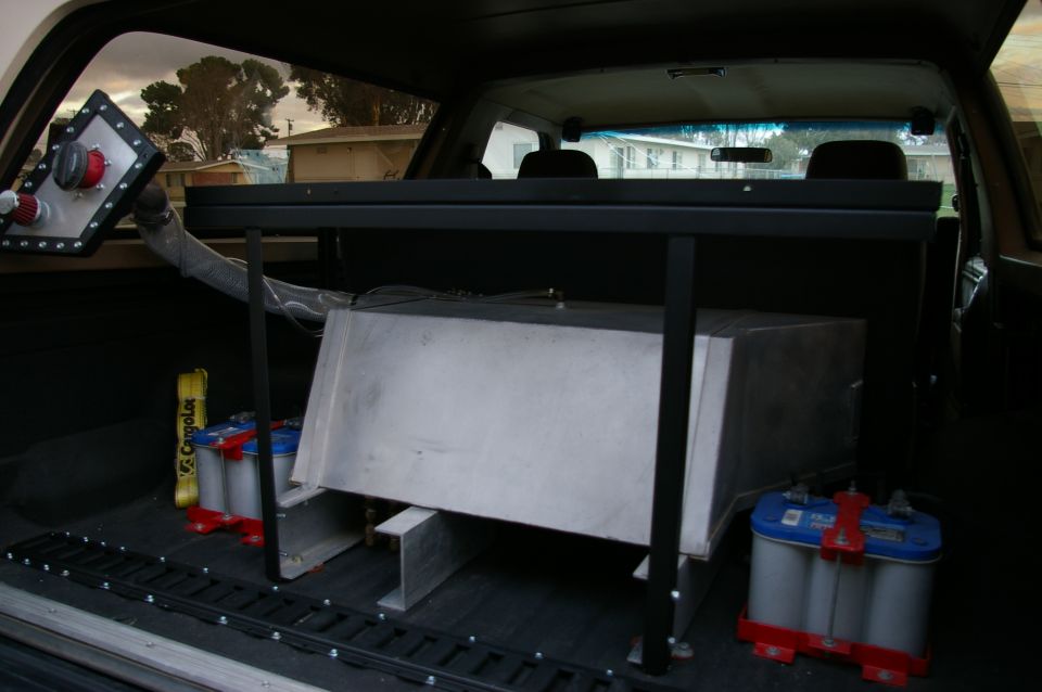 Interior view of a vehicle showing a large metal tank and two batteries