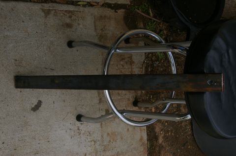 1986 Ford Bronco - A metal bar is placed across the legs and seat of a chrome stool.