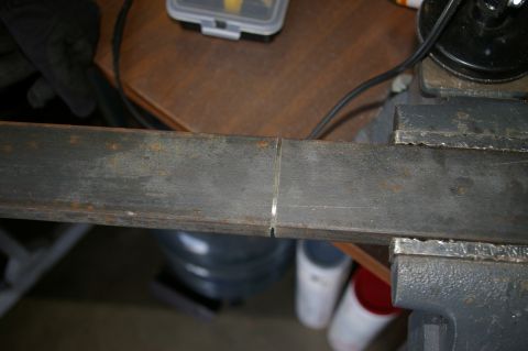 1986 Ford Bronco - A metal bar is secured in a vise, ready for work.