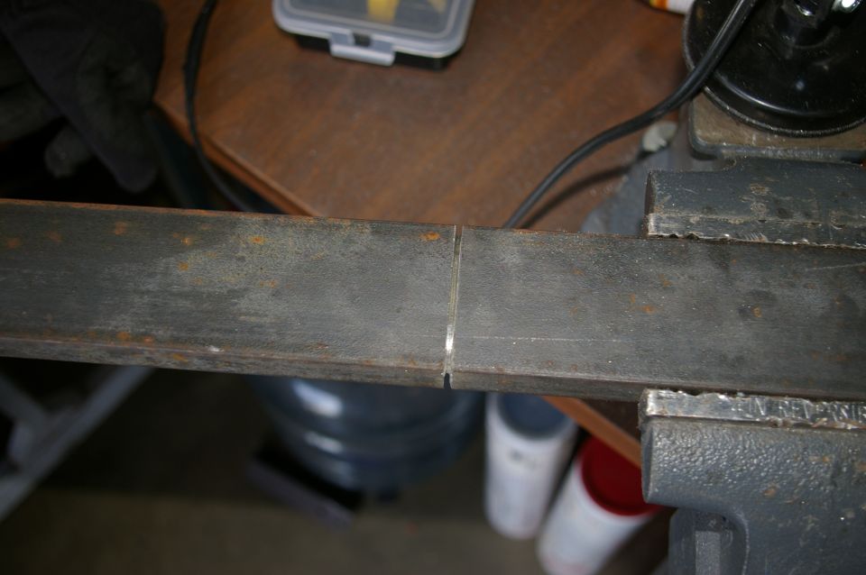 Metal bar held in a vise, with a cut mark in the middle
