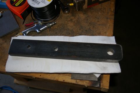 1986 Ford Bronco - A metal clevis mount with three holes is shown on a workbench.
