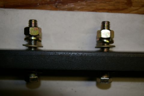 1986 Ford Bronco - Close-up of two clevis mounts, each secured with nuts and washers.