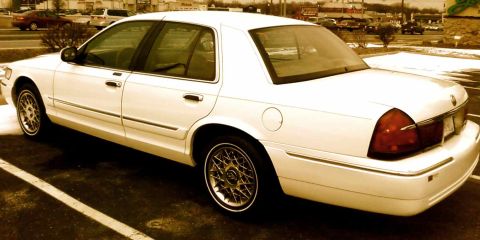2000 Mercury Grand Marquis - This white sedan is parked in a lot, showing its rear quarter panel and taillight.