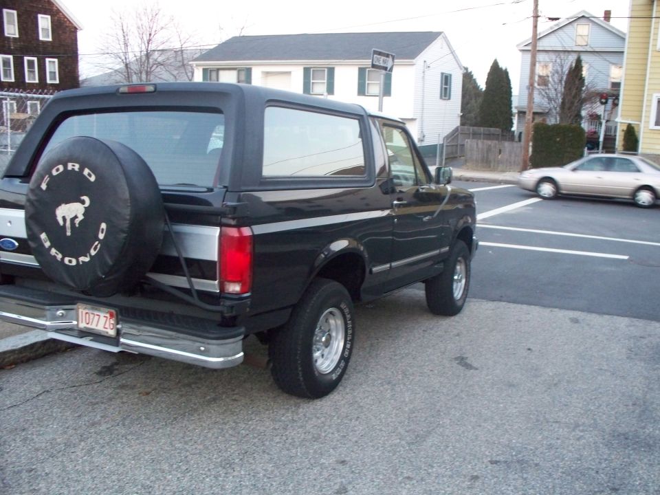 Black Ford Bronco SUV rear three-quarter view parked at a curb