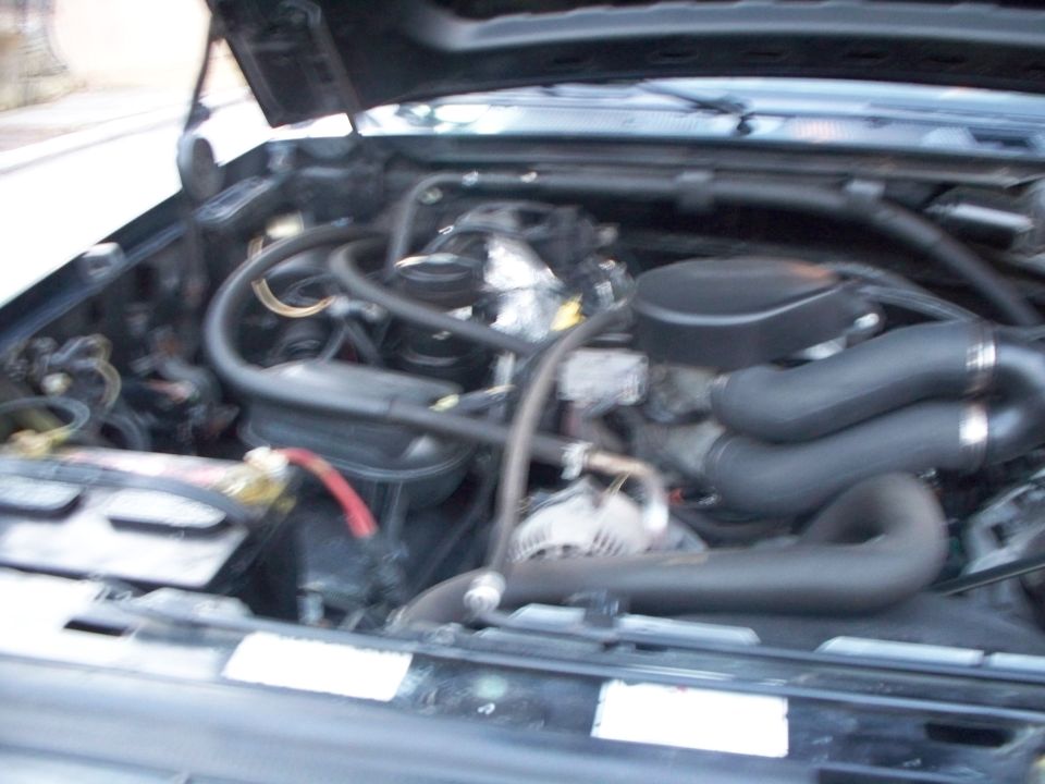 V8 engine bay with chrome intake and supercharger under open hood