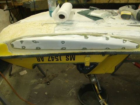 1998 Kawasaki JH1100-A4 1100 ZXi - A jet ski hull is being worked on in a repair shop, with tools and materials visible.