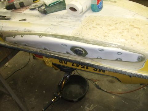 1998 Kawasaki JH1100-A4 1100 ZXi - A jet ski hull is undergoing repair work, showing filler and screw holes on the exterior surface.