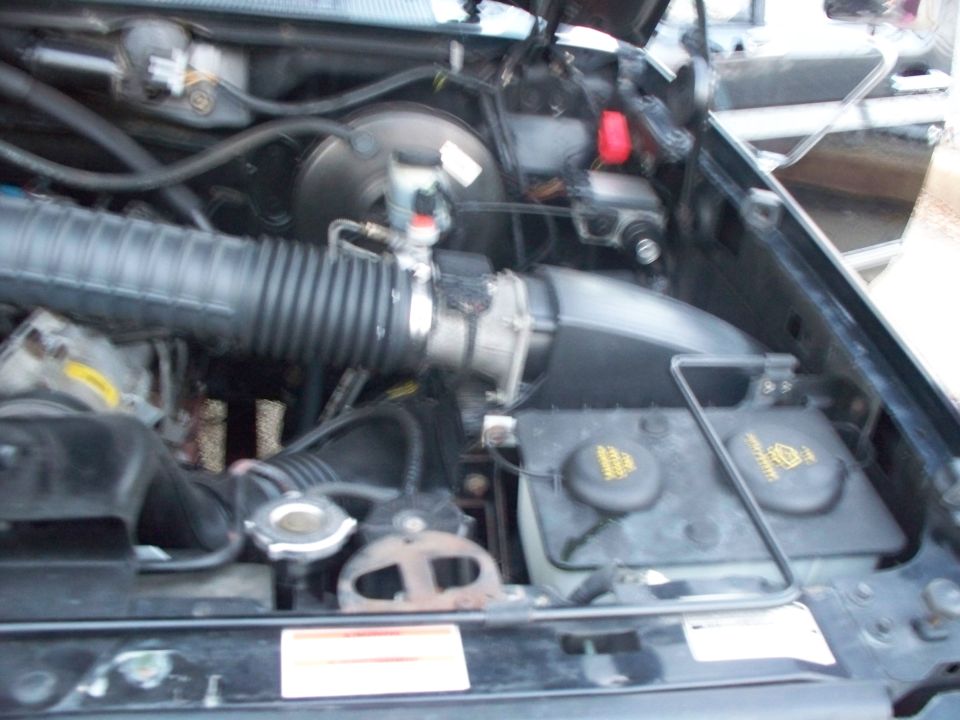 Engine bay showing air intake tube, master cylinder and battery