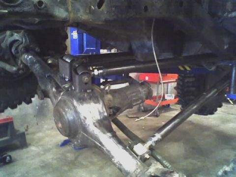 1992 Ford Bronco - Close-up of vehicle undercarriage, focusing on suspension and drivetrain parts.