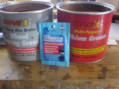 1986 Ford Bronco - Two cans of MAG 1 grease and a packet of connector protector are displayed on a wooden surface.
