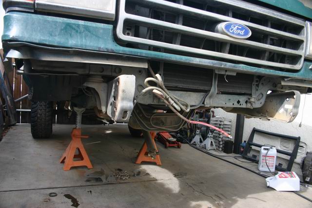 Green 1991 Ford Bronco front end with Ford badge visible, raised on jack stands