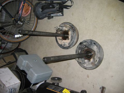 1983 Ferrari Enzo - Axle shafts and brake drums are shown on a garage floor, unrelated to any specific vehicle model.