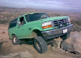 1996 Ford Bronco - 1996 Ford Bronco navigating rough terrain on an off-road trail.